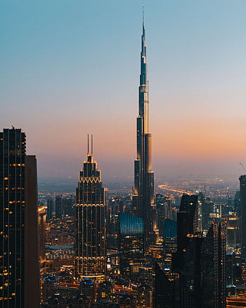 A stunning view of the Dubai skyline with Burj Khalifa during a vibrant dusk. HD phone wallpaper