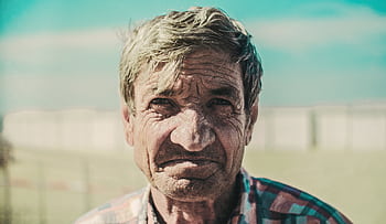 Close-up portrait of an elderly man with wrinkles, outdoors in daylight. HD wallpaper