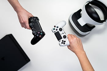 Black and white gaming controllers with VR headset on a minimalist background. HD wallpaper