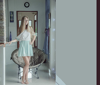Anjelica Ebbi, blue, blonde, wood trim over doors, barefeet, round chair, wine bottle, in hallway, light blue mini dress, clock HD wallpaper
