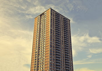 A towering modern skyscraper reaching into the sky in downtown New York City, epitomizing urban architecture. HD wallpaper