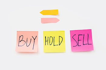 Colorful sticky notes with financial terms 'Buy', 'Hold', and 'Sell' on a clean white backdrop. HD wallpaper