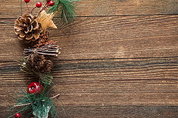 Festive pine cones and holiday decorations on rustic wood background. HD wallpaper
