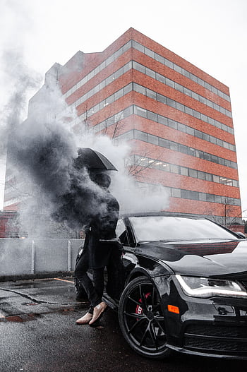 Stylish luxury car with smoke effect in urban Portland setting reflecting modern design. HD phone wallpaper