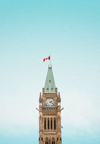 The iconic Peace Tower in Ottawa, Canada, with a clear blue sky and Canadian flag. HD phone wallpaper