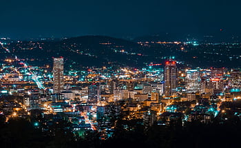 A stunning aerial view of a city skyline illuminated at night, showcasing modern skyscrapers. HD wallpaper