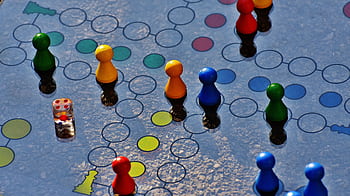 Close-up of a colorful board game with pawns and a dice, perfect for family fun. HD wallpaper