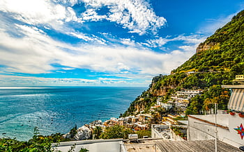 Breathtaking view of the Amalfi Coast with vibrant blue sea and lush green hillsides. HD wallpaper