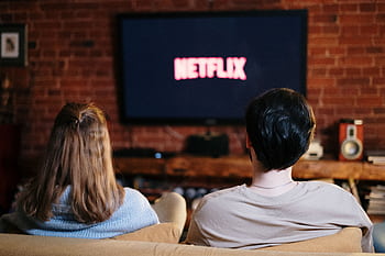 A couple enjoys a relaxed evening watching Netflix in their living room. HD wallpaper