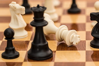 Close-up of chess pieces on a board depicting strategy and challenge. HD wallpaper