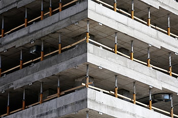 Close-up of an unfinished multi-level concrete building with steel reinforcements. HD wallpaper