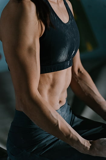 Close-up of a muscular woman resting during an intense workout session indoors. HD phone wallpaper