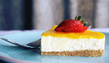 Close-up of a creamy cheesecake slice topped with vibrant strawberries, perfect dessert treat. HD wallpaper