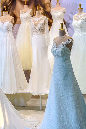 A display of elegant white wedding dresses on mannequins showcasing lace and silk designs. HD phone wallpaper