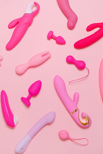 Explore a variety of pink adult toys including vibrators, silicone accessories, and more on a pastel background. HD phone wallpaper