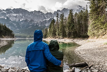 Romantic couple hugging and admiring the view of a mountain lake in Grainau, Germany. HD wallpaper