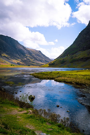 Breathtaking view of a valley with a reflective lake in the Scottish Highlands under a sunny sky. HD phone wallpaper