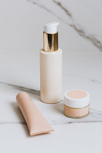 Luxurious skincare products elegantly arranged on a marble surface, showcasing beauty essentials. HD phone wallpaper