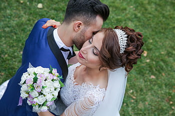 Beautiful outdoor wedding scene with couple embracing, showcasing love and togetherness. HD wallpaper