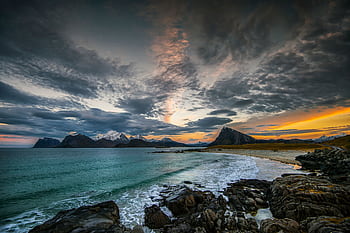 Breathtaking view of a sunset over Nordland's rocky coast with snowy mountains in Norway. HD wallpaper