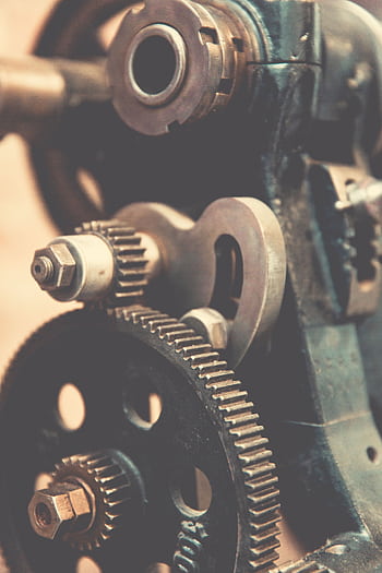 Detailed view of vintage industrial machinery gears showcasing precision engineering. HD phone wallpaper