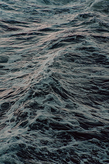 Energized ocean waves showcasing motion and power during sunset. HD phone wallpaper