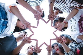 A circle of friends forming a star shape with fingers, symbolizing unity and teamwork. HD wallpaper