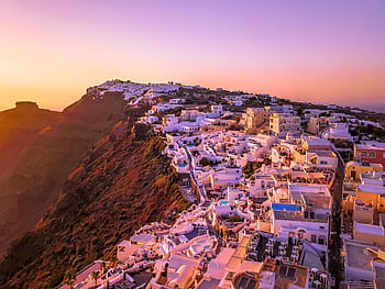 A breathtaking aerial view of Santorini at sunset showcasing iconic architecture and vibrant colors. HD wallpaper