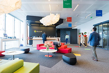 Contemporary office reception area with vibrant seating and professional ambiance. HD wallpaper