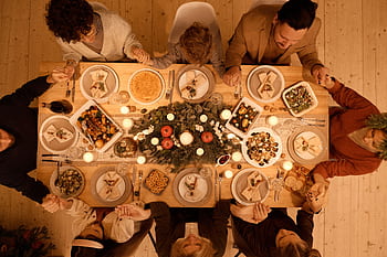 Family gathered around a beautifully set table for a festive Christmas dinner celebration. HD wallpaper