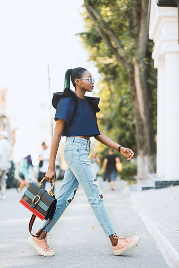 Stylish woman with trendy bag and sunglasses walks confidently down the street. HD phone wallpaper