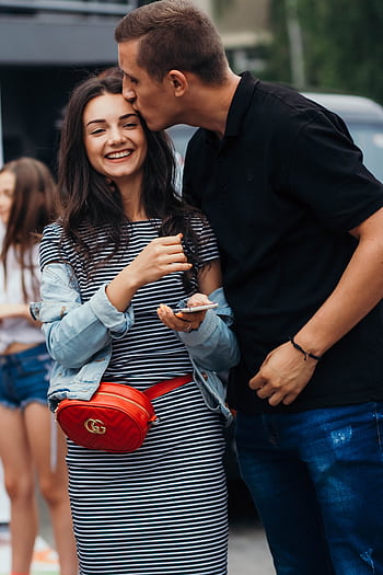 Smiling couple sharing an affectionate moment outdoors. HD phone wallpaper