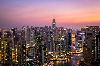 Captivating view of Dubai's skyline at dusk with vibrant city lights and skyscrapers. HD wallpaper