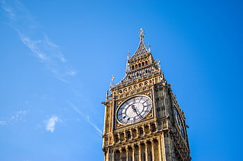 Stunning low angle view of Big Ben clock tower with a clear blue sky background, London landmark. HD wallpaper
