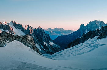 Serene view of snow-capped mountains at sunrise, capturing the tranquility of the French Alps. HD wallpaper
