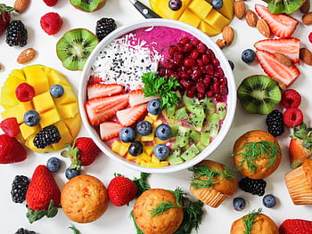 Vibrant smoothie bowl topped with assorted fresh fruits and muffins, perfect for a healthy snack. HD wallpaper