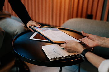 Business professionals exchanging resume during meeting, focusing on career advancement. HD wallpaper