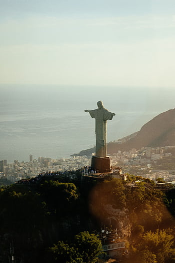 Majestic aerial view of Christ the Redeemer statue overlooking Rio de Janeiro at sunset. HD phone wallpaper