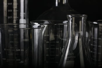 A detailed close-up of various transparent laboratory glassware used in scientific experiments. HD wallpaper