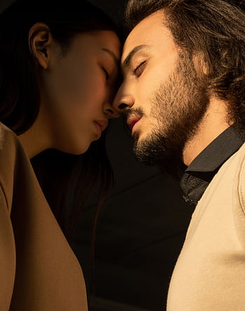 A close portrait of a couple with closed eyes sharing an intimate moment. HD phone wallpaper