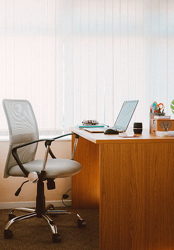 A tranquil modern home office featuring a wooden desk, ergonomic chair, and soft natural light. HD phone wallpaper
