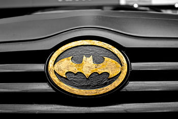 A detailed of the iconic Batman logo on a car's grill, highlighting superhero symbolism. HD wallpaper
