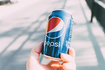 Refreshing Pepsi can held in hand on a sunny day. Perfect for advertisements. HD wallpaper