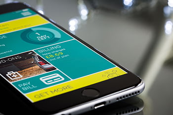 Close-up of a smart displaying a billing app interface on a reflective surface. HD wallpaper
