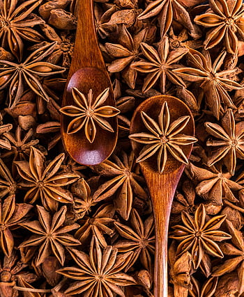 Aesthetic flat lay of star anise and wooden spoons, highlighting spice and culinary themes. HD phone wallpaper