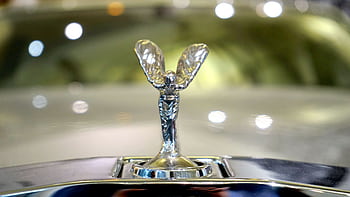 Detailed shot of a luxury car emblem reflecting the elegance and style of automobile design. HD wallpaper