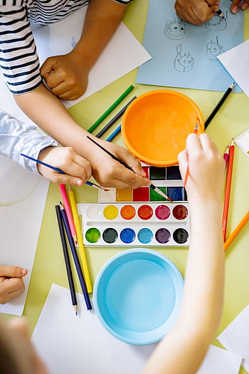 Kids enjoying watercolor painting, enhancing creativity and learning in a fun environment. HD phone wallpaper
