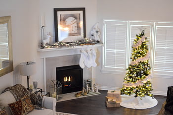 Warm and inviting living room decorated for Christmas with a beautifully lit tree and fireplace. HD wallpaper