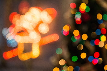 Vibrant out-of-focus holiday lights creating a festive bokeh effect with bright colors. HD wallpaper