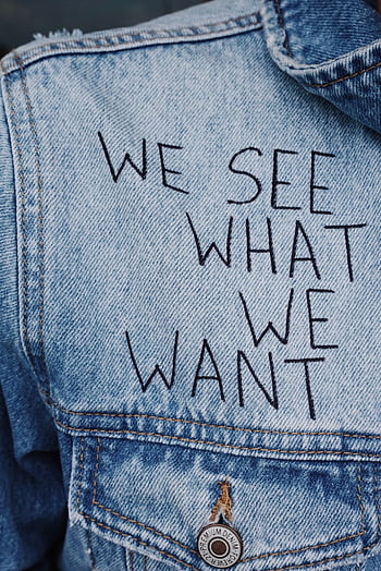 Close-up of denim jacket featuring the phrase 'We See What We Want' embroidered. HD phone wallpaper